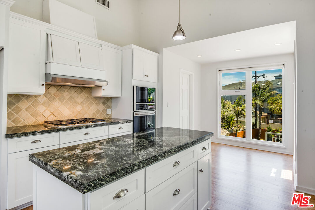 224 Sunridge Street Playa del Rey, CA 90293 - Photo 11 of 44 a kitchen with stainless steel appliances granite countertop a stove a sink and a white cabinets