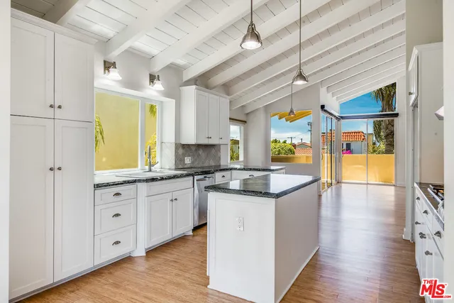 a kitchen with stainless steel appliances granite countertop a sink and wooden floors
