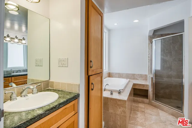 a bathroom with a granite countertop sink and a mirror