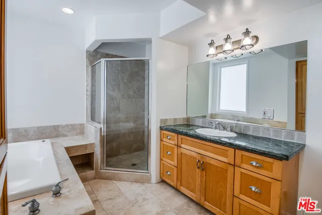 a bathroom with a granite countertop sink a mirror and a shower