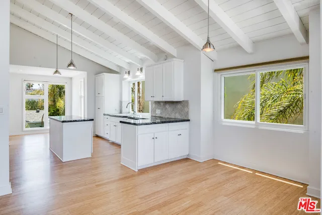 a kitchen with wooden floors and white walls