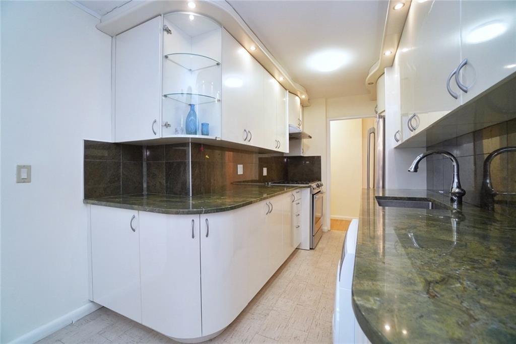 35 Seacoast Terrace, Unit 2N Brooklyn, NY 11235 - Photo 11 of 38 a kitchen with granite countertop a sink a stove and cabinets