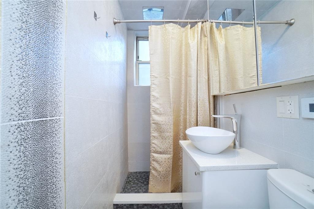 35 Seacoast Terrace, Unit 2N Brooklyn, NY 11235 - Photo 23 of 38 a bathroom with a sink a toilet and shower