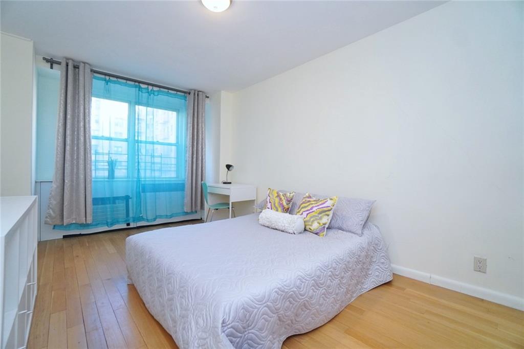 35 Seacoast Terrace, Unit 2N Brooklyn, NY 11235 - Photo 26 of 38 a bedroom with a bed and wooden floor