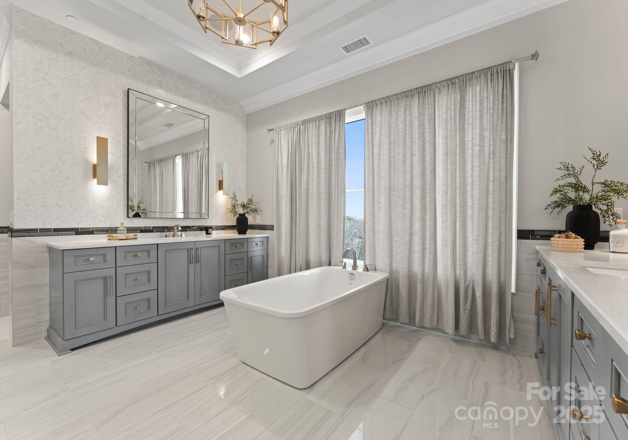 19329 Watermark Drive, Unit 551 Cornelius, NC 28031 - Photo 13 of 25 a spacious bathroom with a double vanity sink a mirror a bathtub and shower