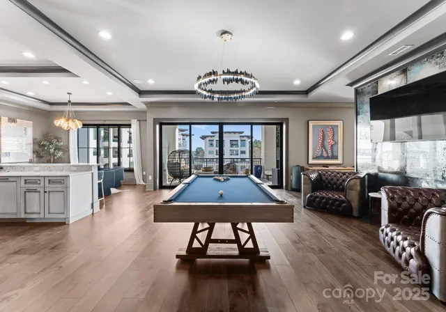 a living room with furniture a wooden floor and chandelier
