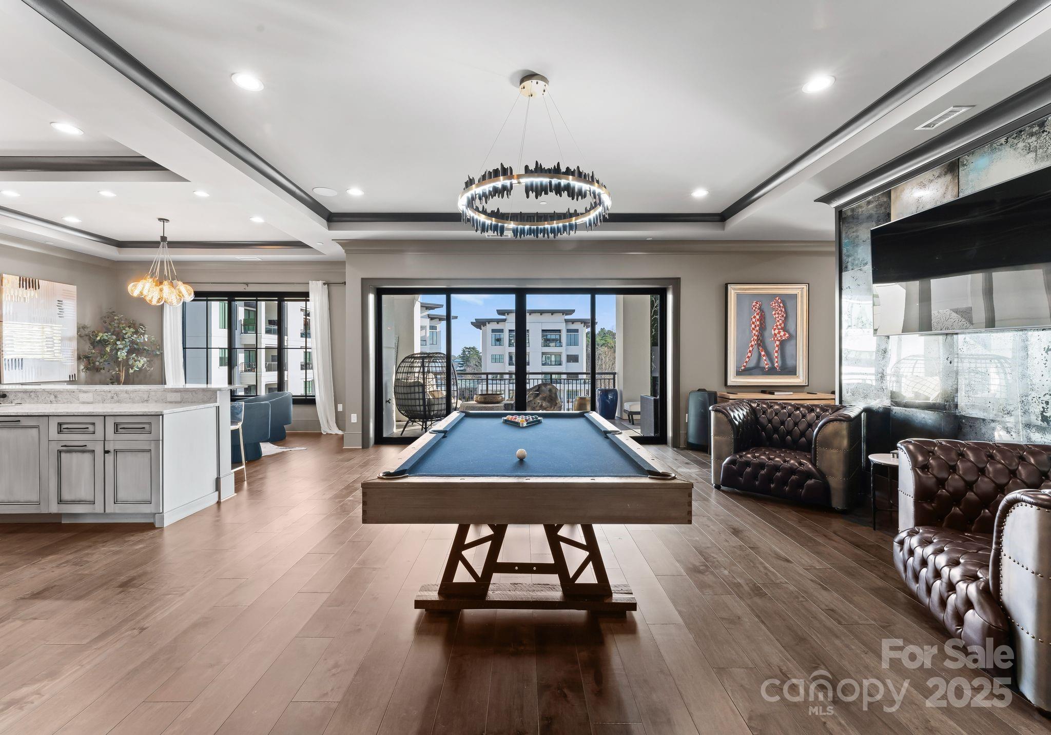 19329 Watermark Drive, Unit 551 Cornelius, NC 28031 - Photo 4 of 25 a living room with furniture a wooden floor and chandelier