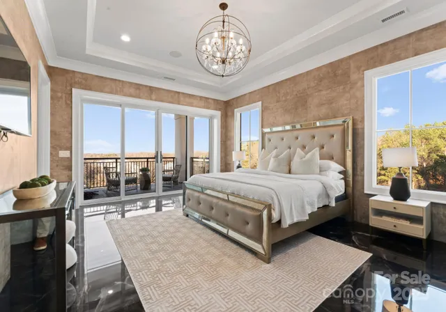 a bedroom with a large bed and a chandelier