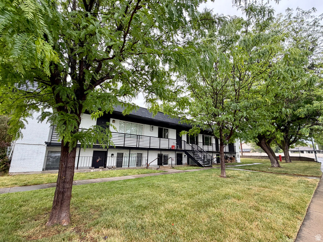 895 East Arrowhead Lane Murray, UT 84107 - Photo 11 of 12 Two-story building featuring white brick facade, black railing balconies, exterior staircases, and a dark shingle roof