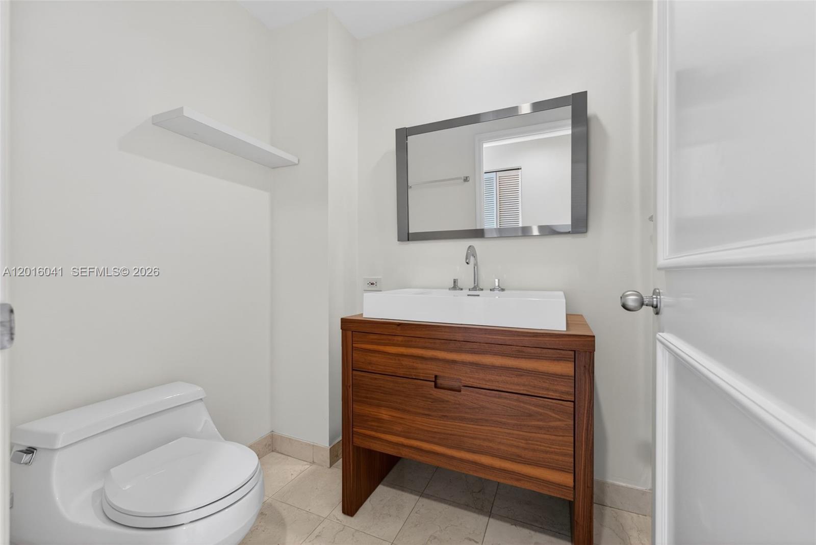 808 Brickell Key Drive, Unit 3304 Miami, FL 33131 - Photo 24 of 70 a bathroom with a sink a toilet and mirror