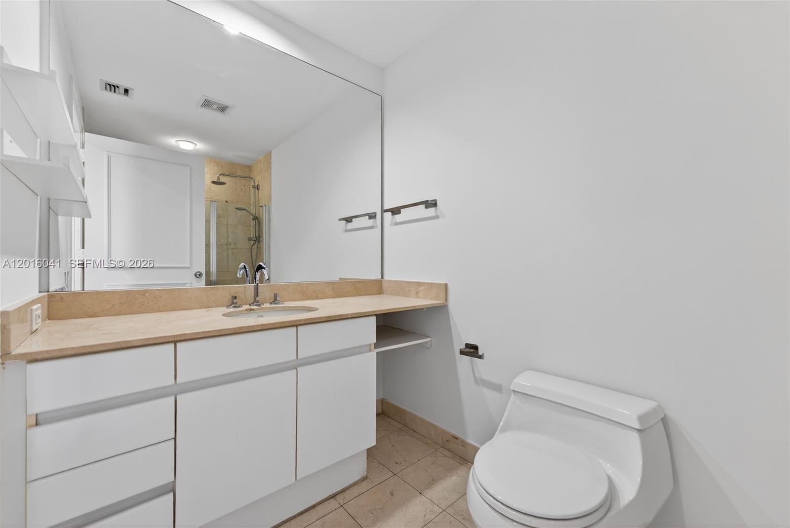 808 Brickell Key Drive, Unit 3304 Miami, FL 33131 - Photo 35 of 70 a bathroom with a toilet a sink a mirror and vanity