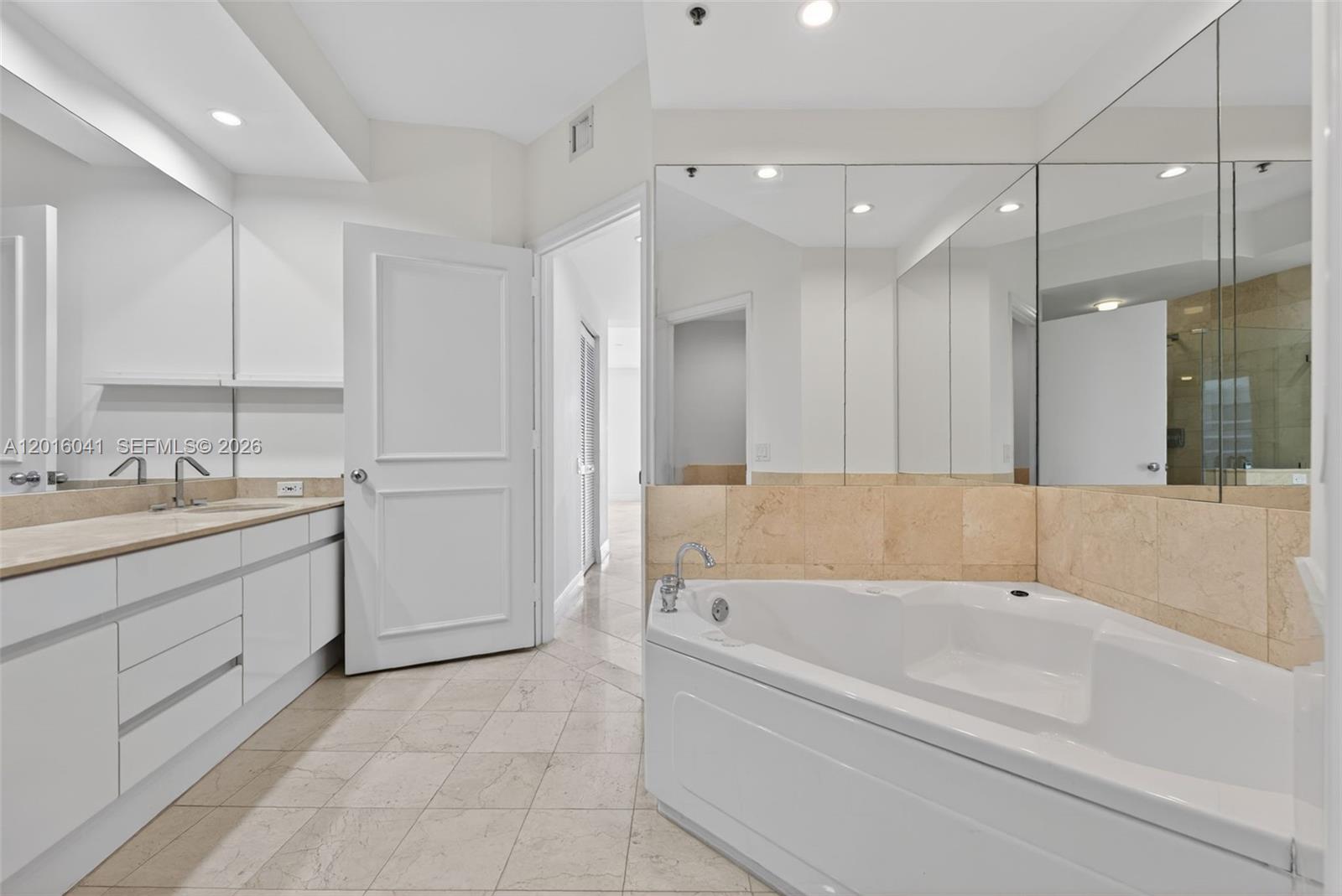 808 Brickell Key Drive, Unit 3304 Miami, FL 33131 - Photo 39 of 70 a large spacious bathroom with a tub sink shower and mirror