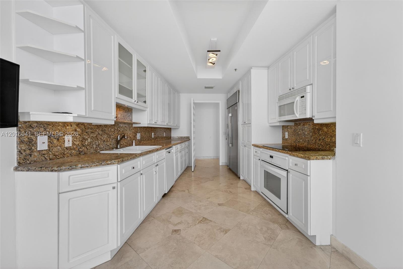 808 Brickell Key Drive, Unit 3304 Miami, FL 33131 - Photo 49 of 70 a kitchen with granite countertop a sink and cabinets