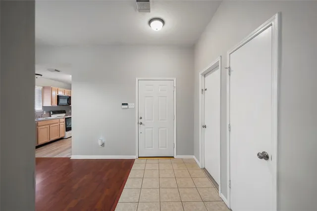 a view of a hallway with wooden floor and a living room