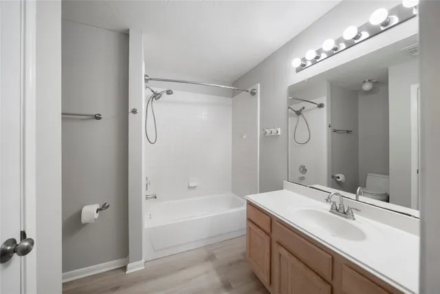a bathroom with a tub sink double vanity and a mirror