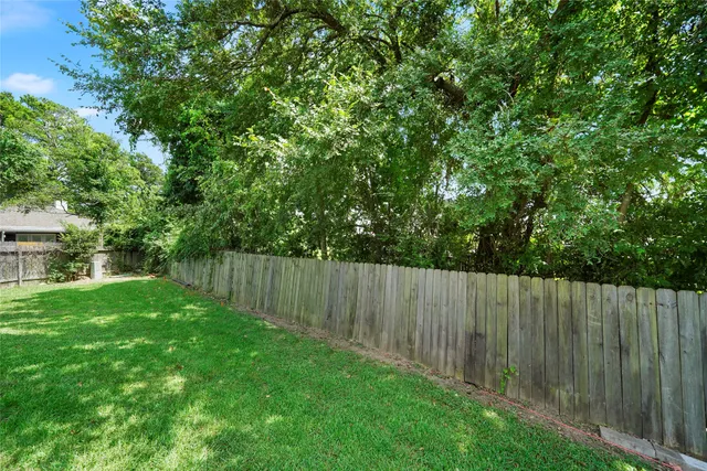a view of a backyard with wooden fence