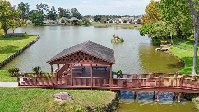 an aerial view of a house with swimming pool a yard and lake view