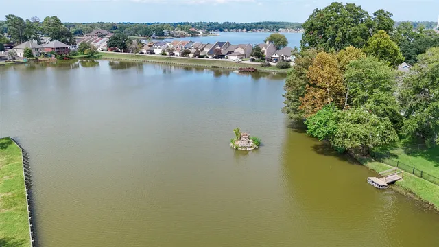 an aerial view of a residential houses with outdoor space and lake view