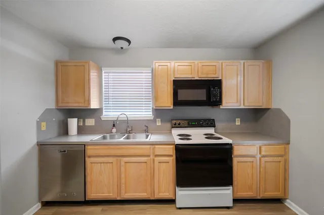 a kitchen with stainless steel appliances granite countertop a sink a stove and a microwave