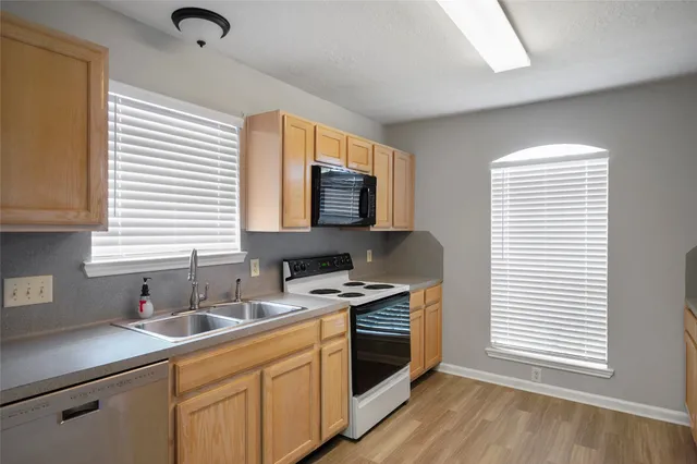 a kitchen with stainless steel appliances a sink a stove a microwave and cabinets