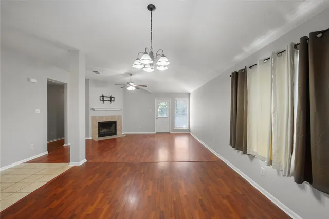 a view of empty room with wooden floor and fireplace