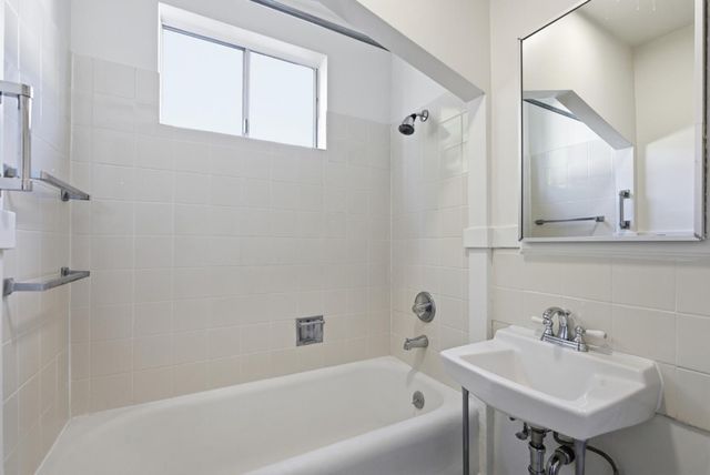 a bathroom with a sink mirror and a bathtub