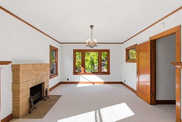 a view of an empty room with a fireplace and a window