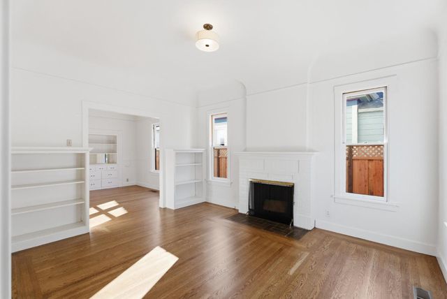 a view of a livingroom with wooden floor and a fireplace