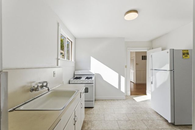 a kitchen with a refrigerator sink stove and cabinets