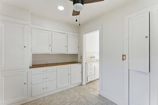 a kitchen with a refrigerator and white cabinets