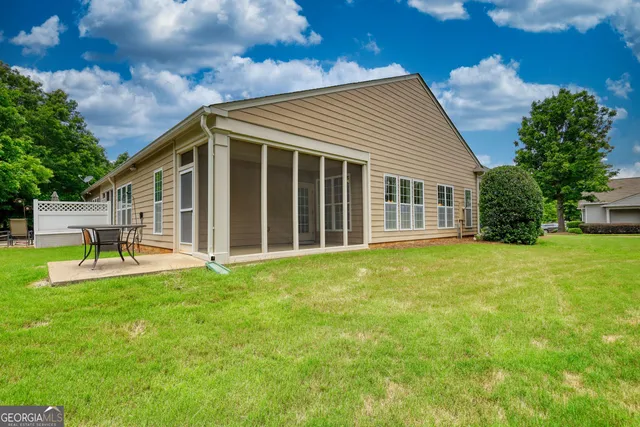 a view of a house with a backyard and a patio