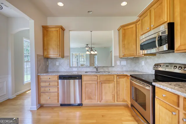 a kitchen with stainless steel appliances granite countertop a stove a sink and a microwave
