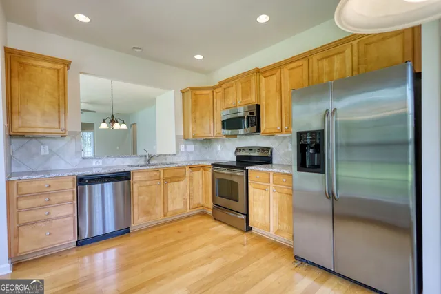 a kitchen with stainless steel appliances a refrigerator sink and microwave