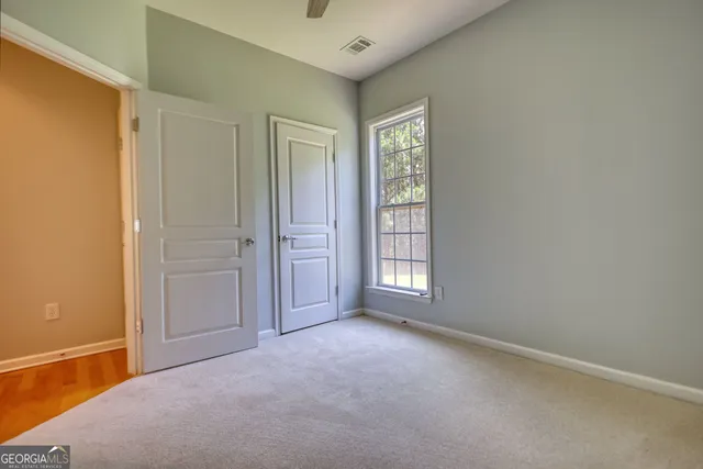an empty room with windows and closet