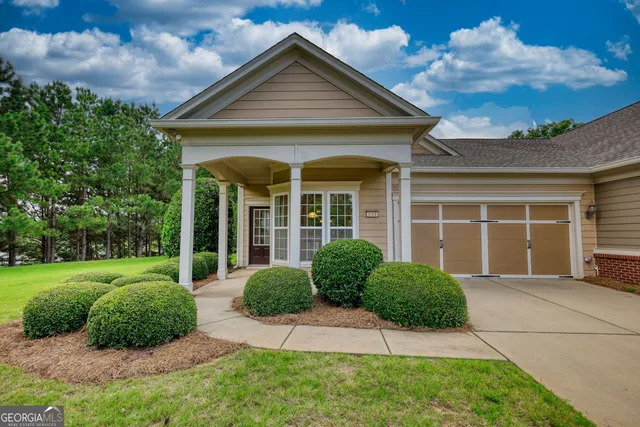 a front view of a house with a yard and potted plants