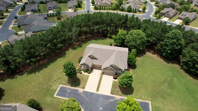 an aerial view of a house with a garden and lake view
