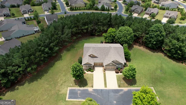 an aerial view of a house with swimming pool and garden