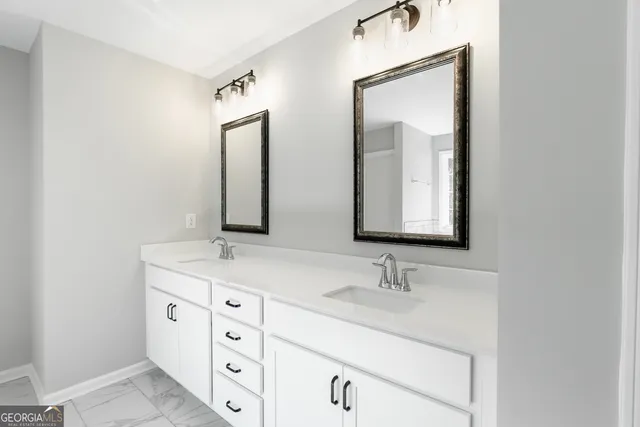 a bathroom with double sink and two mirror