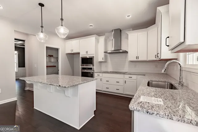 a kitchen with stainless steel appliances kitchen island granite countertop a sink a stove and cabinets