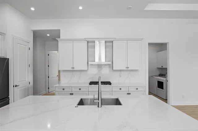a kitchen with white cabinets and appliances