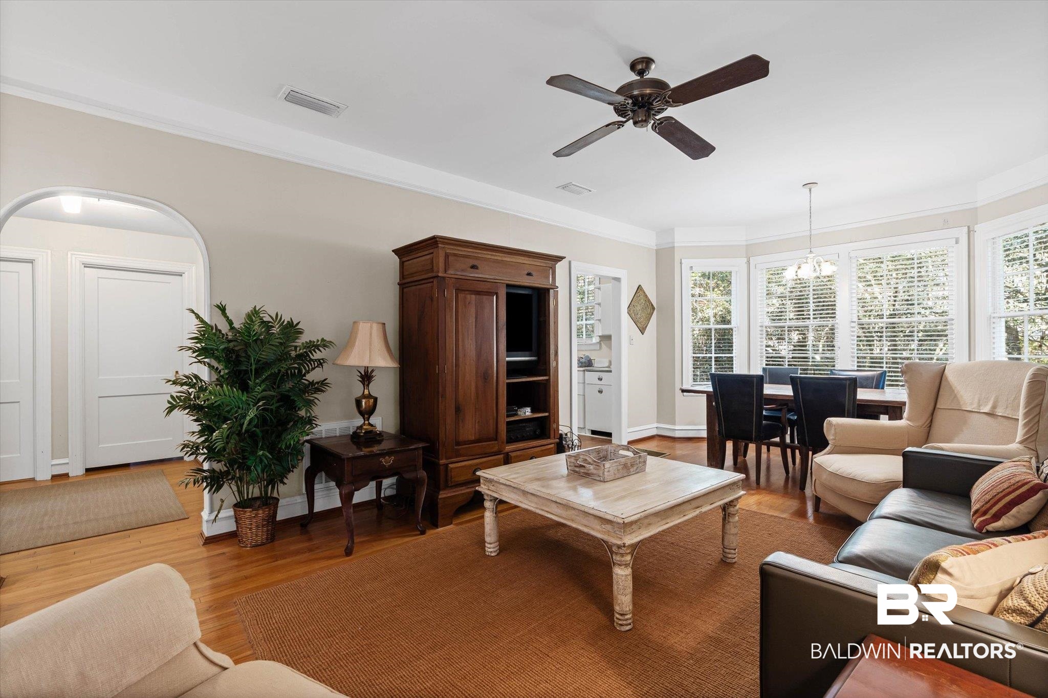 7015 Bay Road Mobile, AL 36605 - Photo 33 of 53 Gluest cottage Living room featuring wood finished floors, ceiling fan, ornamental molding, and a chandelier