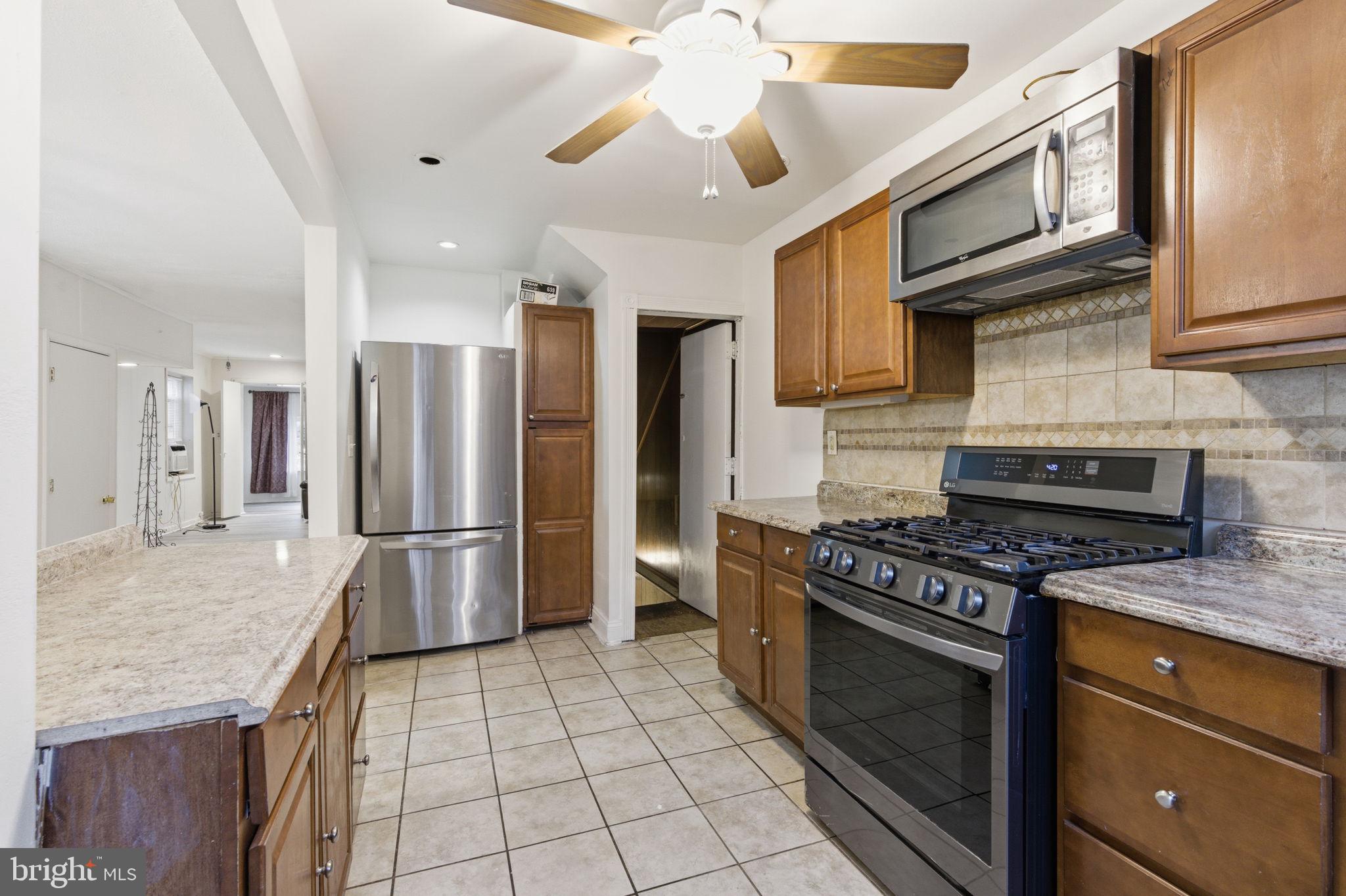 212 Upland Road Merion Station, PA 19066 - Photo 10 of 32 a kitchen with stainless steel appliances granite countertop a stove a refrigerator and a cabinets