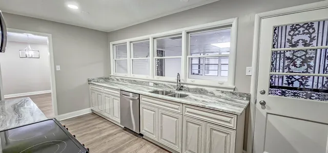 a kitchen with stainless steel appliances granite countertop a sink stove and cabinets