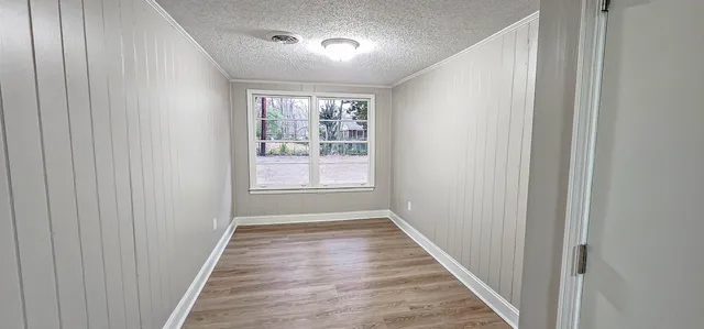 a view of a hallway with wooden floor and a window