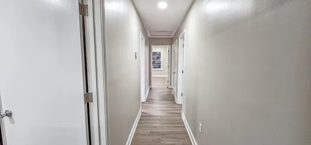 a view of a hallway with wooden floor