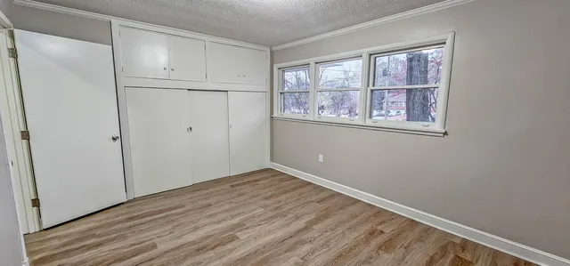 a view of empty room with window and wooden floor