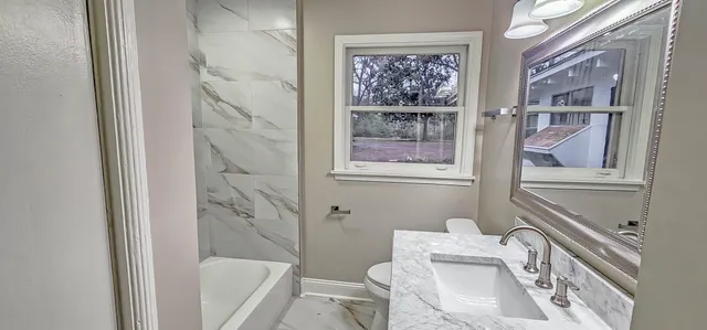 a bathroom with a sink a toilet and shower