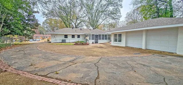 a front view of a house with yard and trees around