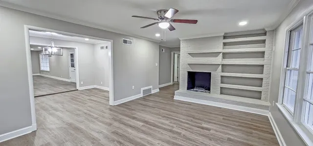 a view of an empty room with a fireplace and a window