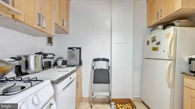 a kitchen with a refrigerator and a stove top oven
